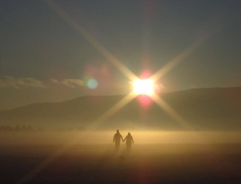 Couple walking hand in hand in sunset