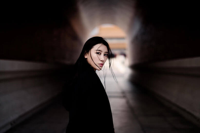 Girl in tunnel turning around looking at camera giving eye contact attraction