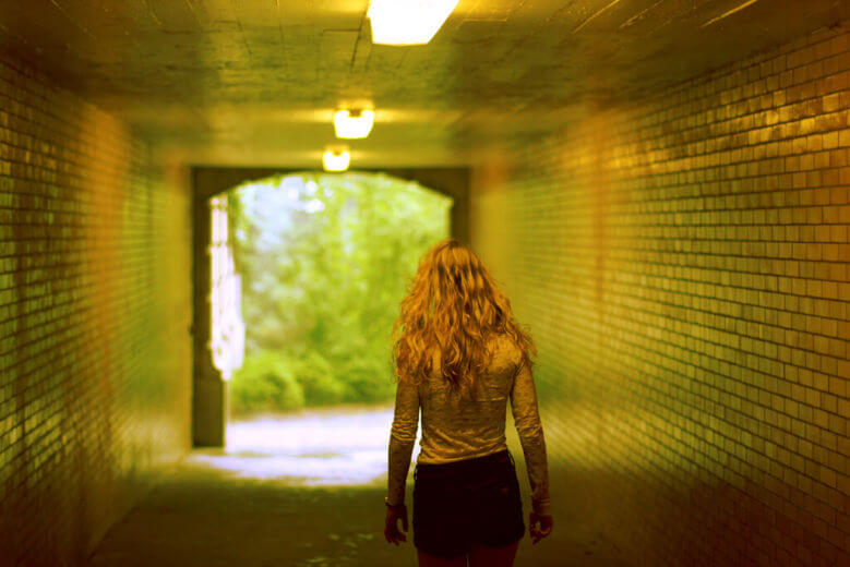 Girl walking through a tunnel