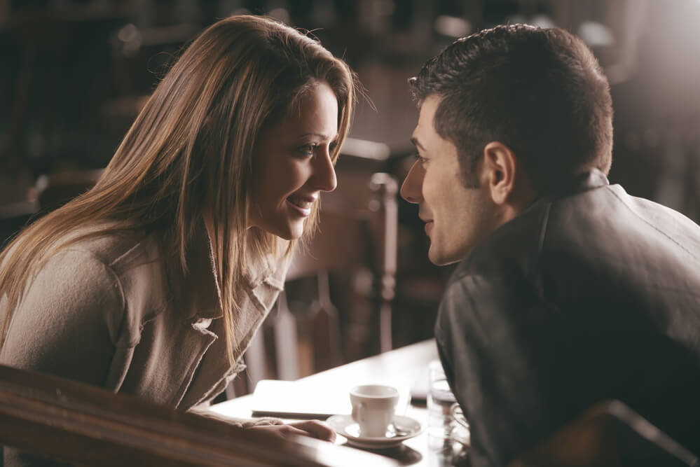 Romantic couple at the bar staring at each other's eyes