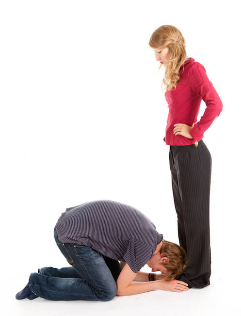 Man kneeling at the feet of woman, white background