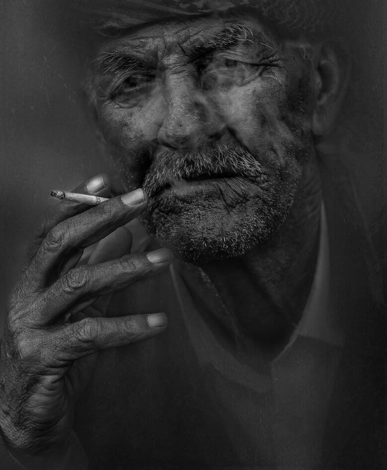 Old smoker with a cigarette in hand