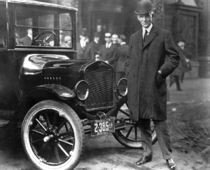 Man standing next to car in old black and white photo