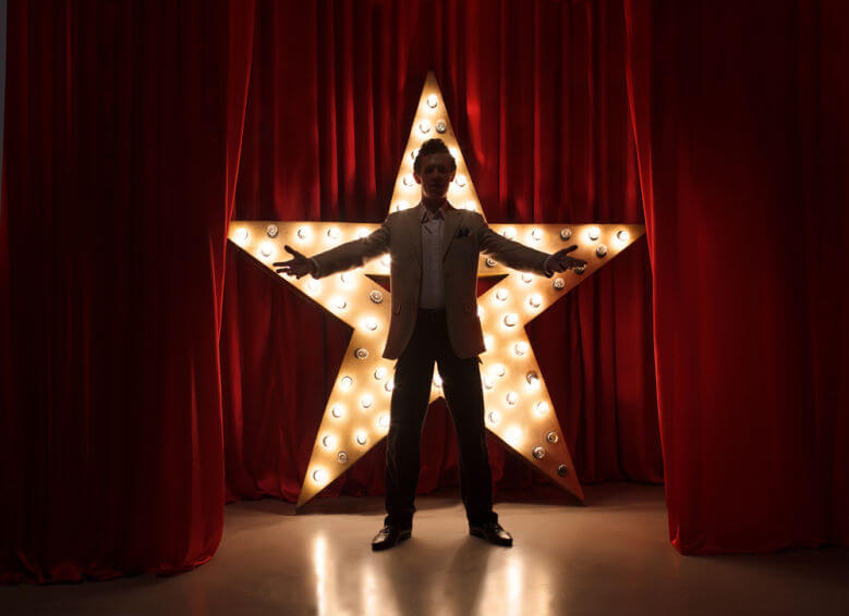 Man on stage with star on background