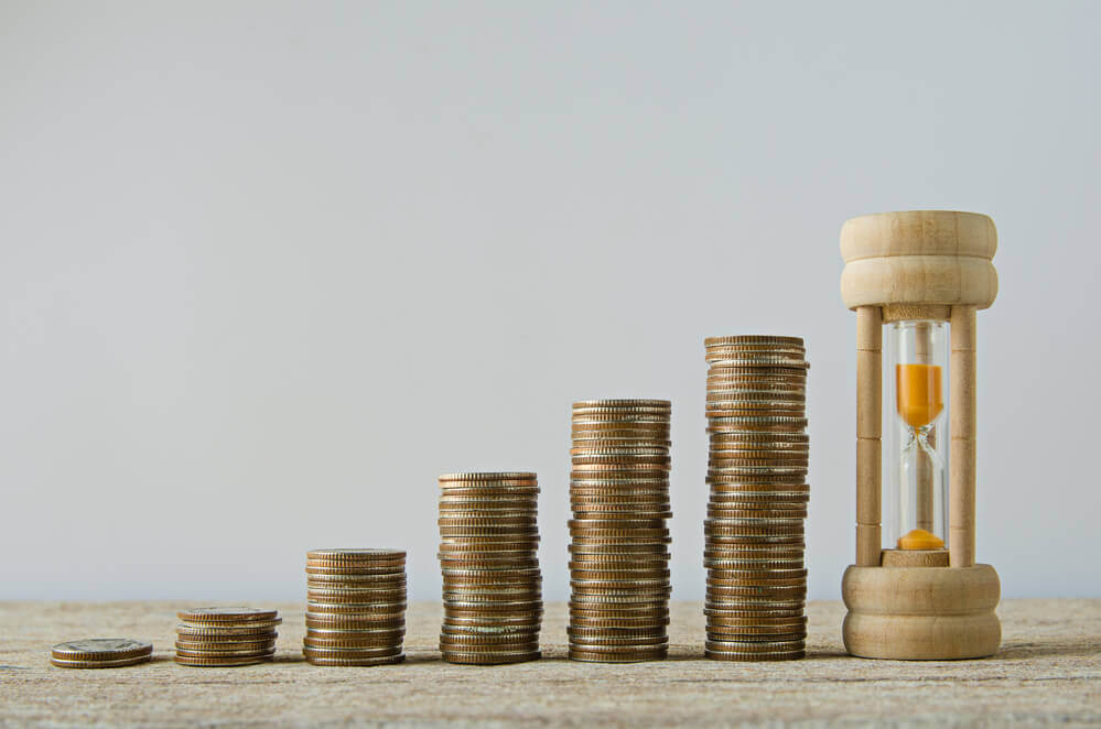 coins stacked with an hourglass