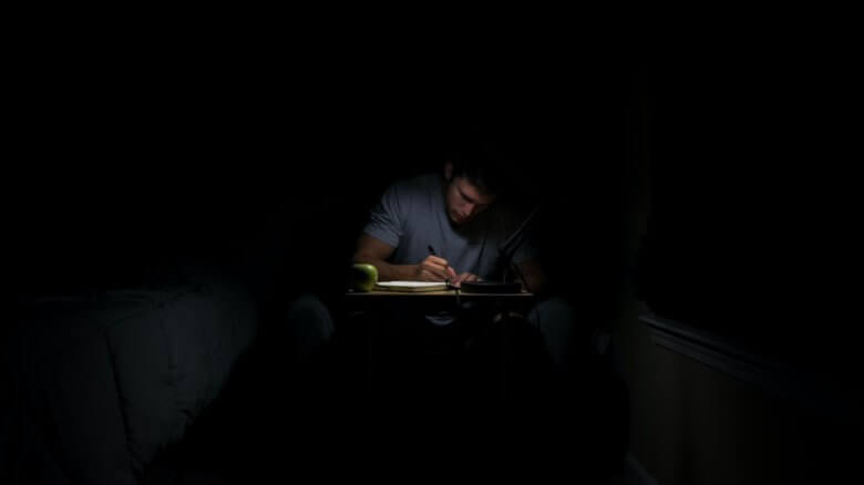 Man journaling under lamp